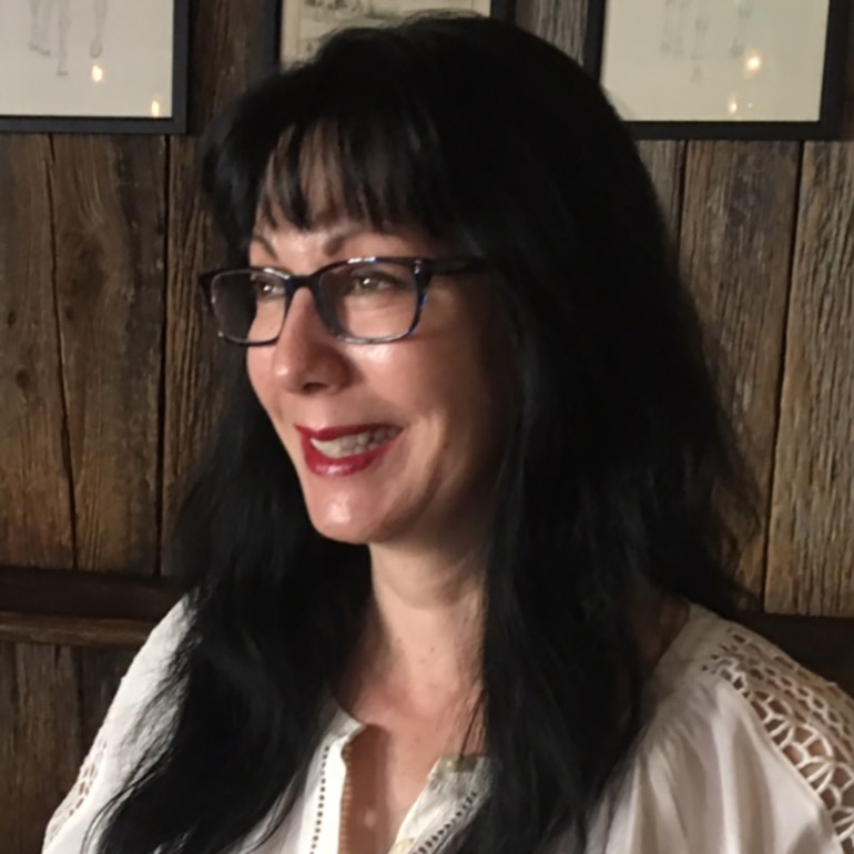 a picture of Lisa Morgin wearing glasses and smiling